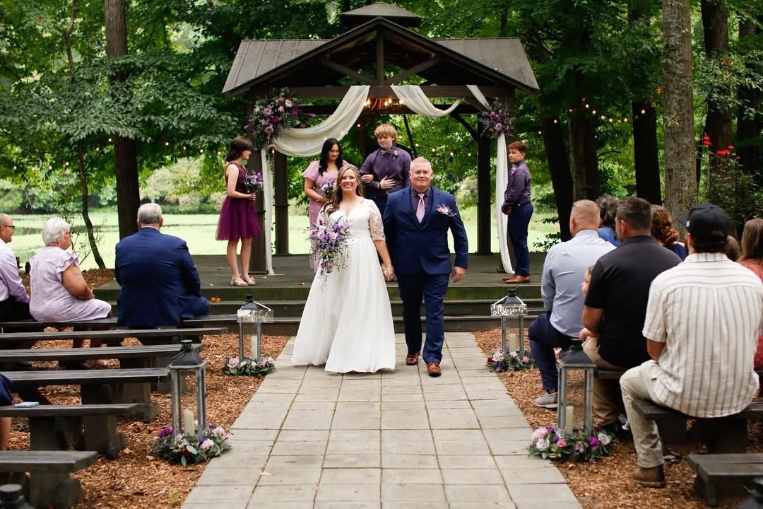 Newly married couple walking down the aisle after an outdoor wedding ceremony
